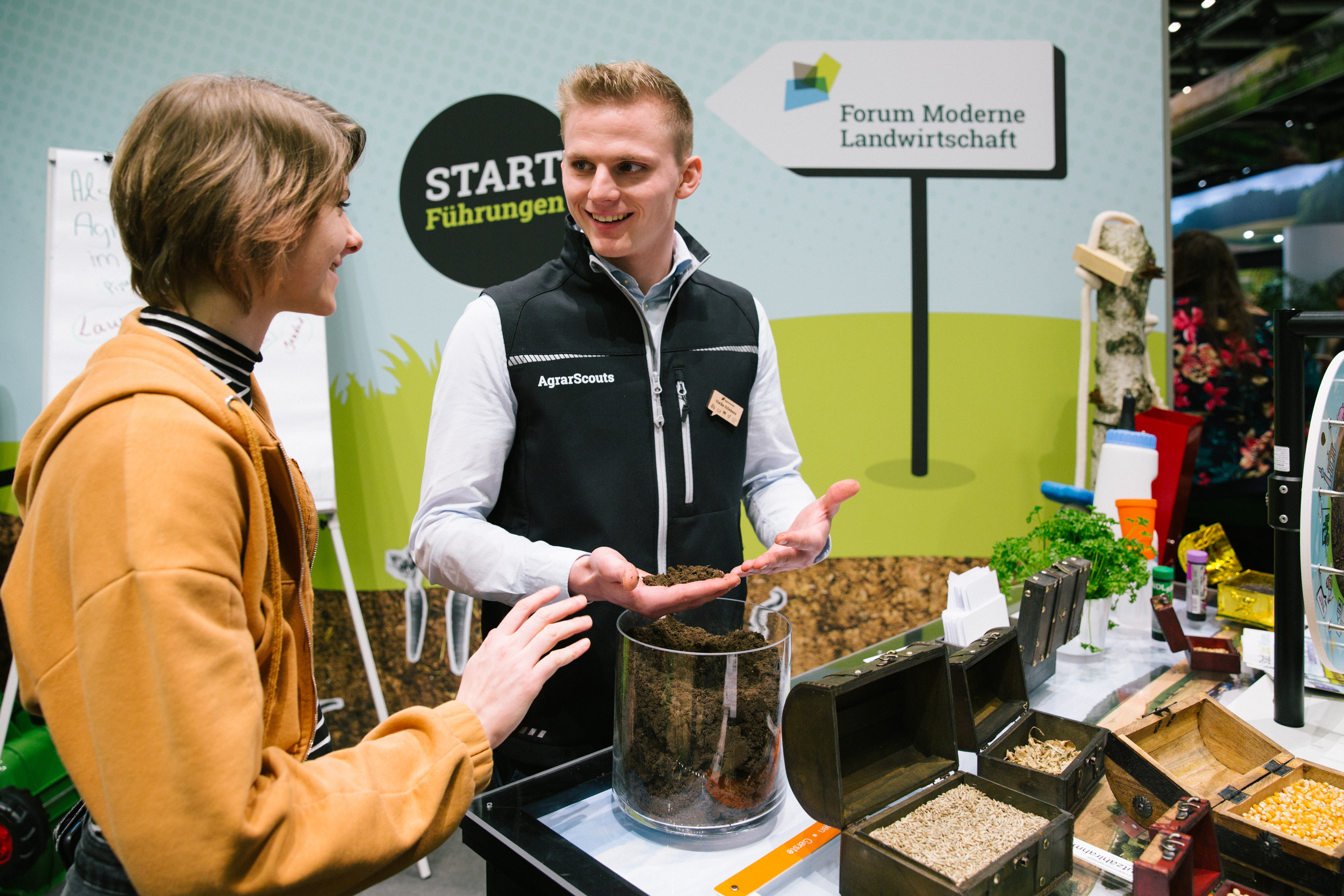 A couple stands near a table adorned with various plants, creating a serene and natural ambiance.