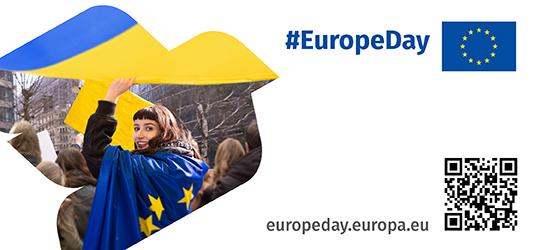 image of a girl in a crowd, waving and wearing an EU flag. #EuropeDay