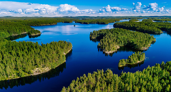 Aerial view of blue lakes and green forests on a sunny summer day in Finland