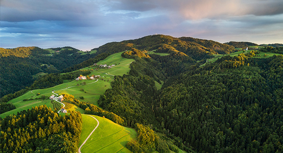 Aerial shot of green hills of Slovenia at sunrise